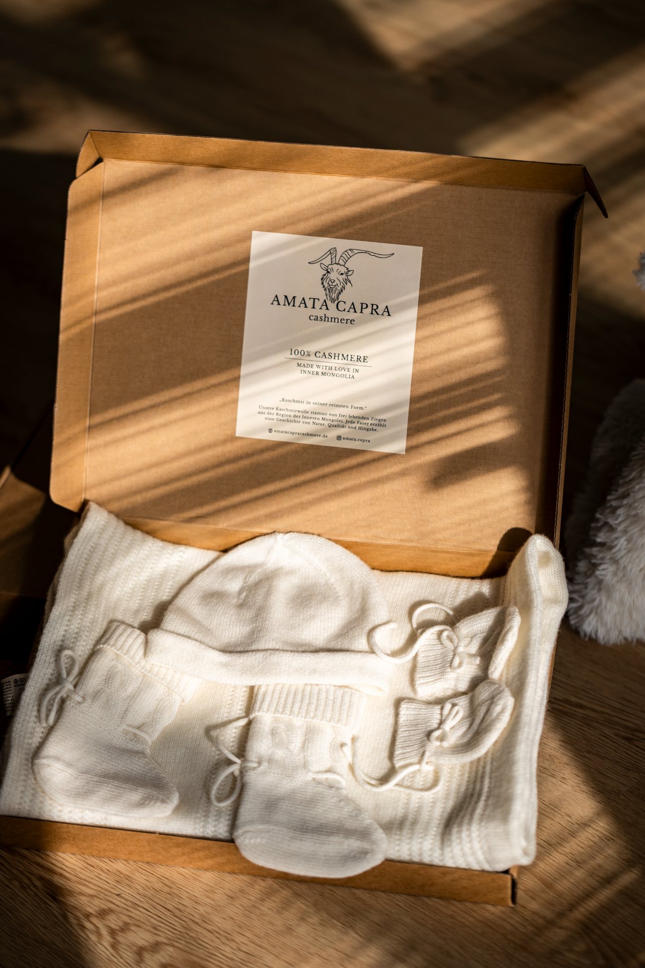 Das Babyset aus reinem Kaschmir, geschenkfertig in der Kraftpapier-Box